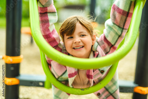 Happy child girl on playground on summer season