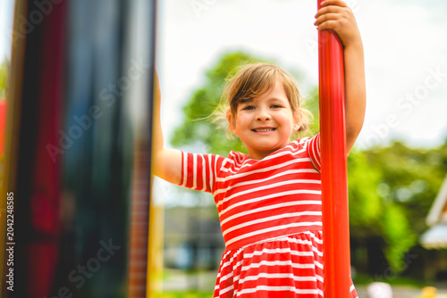 Happy child girl on playground on summer season