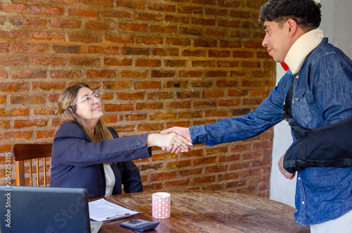 Bild auf Leinwand Mature adult female lawyer or social worker shaking hands with injured man victi