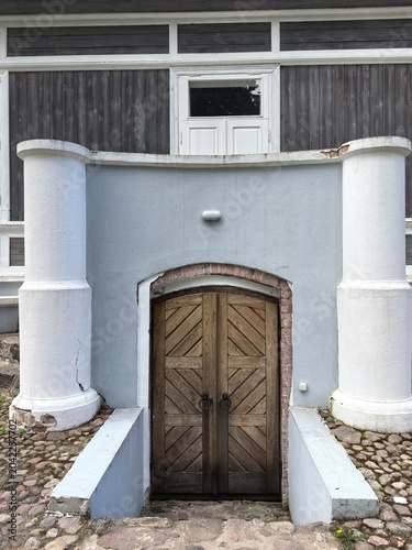 Fotografie Traditional 19th-century estate architecture featuring brick archway and wooden basement doors