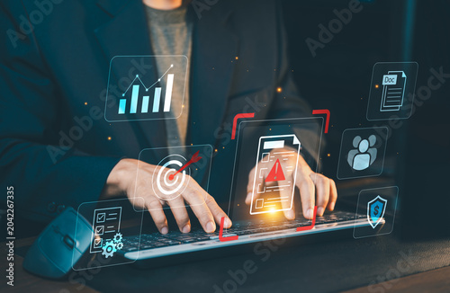 Businessman typing on keyboard working with digital document alert error exclamation mark on virtual screen. Risk management and business concept.