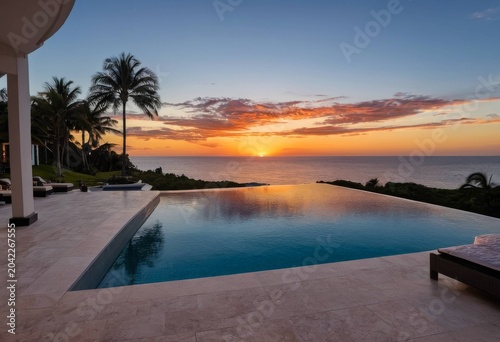 Luxury infinity pool merging with the ocean at sunset