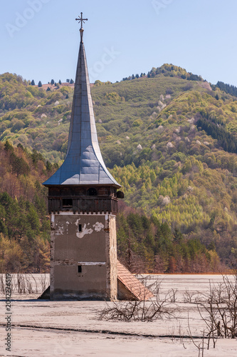 Church tower rising from the toxic tailings lake of Geamana, flooded by mining waste from Roșia Poieni copper mine, Apuseni Mountains, Romania. 