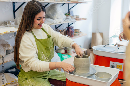 Obraz na plátně Young woman shaping clay on a pottery wheel