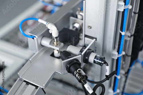 Foto Industrial automation sensors and pneumatic components on manufacturing equipmen