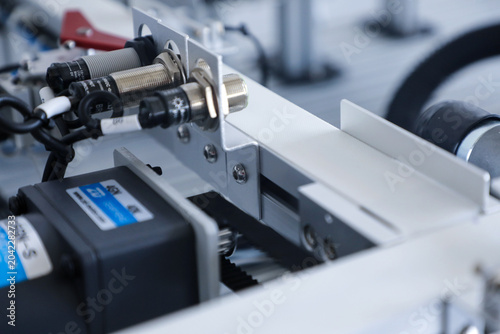 Fotografija Industrial automation machine with proximity sensors and conveyor mechanism