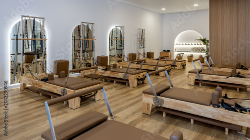 Fotografie Wooden reformer machines arranged in a modern pilates training room