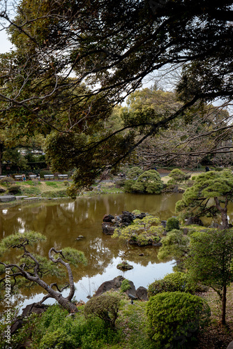 Tokyo, Japan - March 28, 2026: Garden pond surrounded by trees at Hibiya Park in Tokyo, Japan
