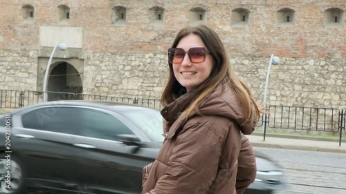 Young female tourist exploring historic European city square in spring