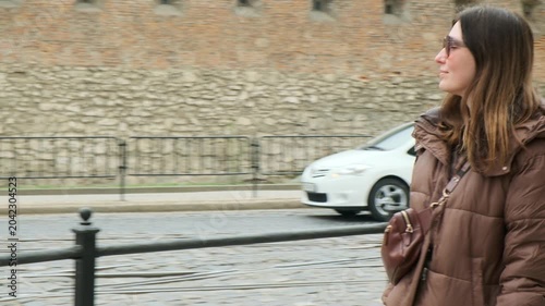 Young female tourist exploring historic European city square in spring