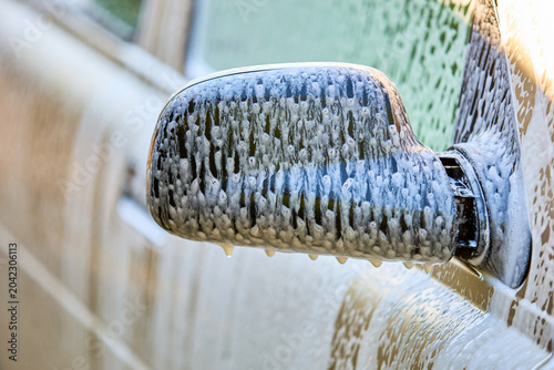 Photos Close-up of car side mirror with soap suds during a wash