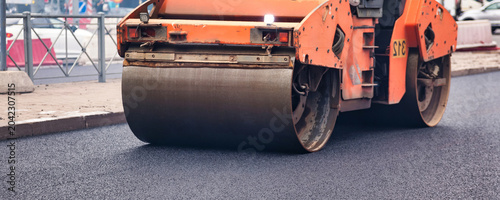 Foto Urban Street Paving With Heavy Machinery During Road Construction on a Busy City