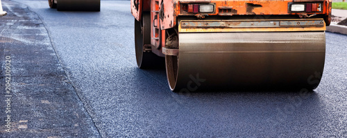 Tableau sur toile Paving Asphalt Concrete on a Busy City Street During Road Construction Activitie