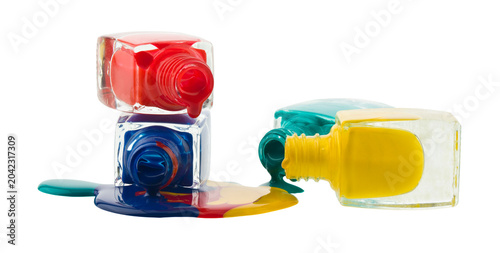 Red, green, blue and yellow bottles of nail polish isolated on white background.