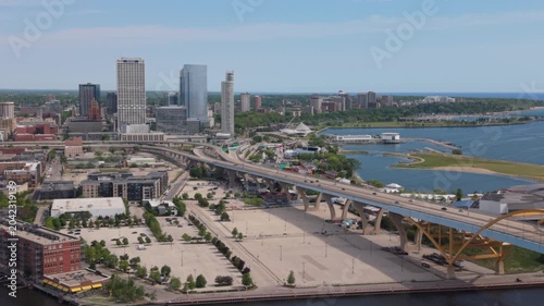 tighter aerial view of downtown Milwaukee flying back past smokestack
