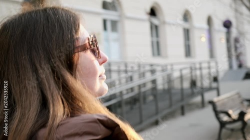 Young woman walking in European city street at sunrise