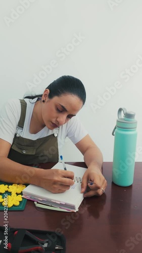 Focused creative woman writing ideas in notebook