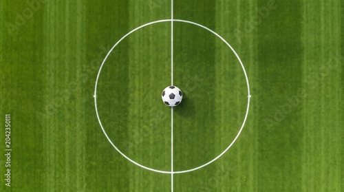 Minimalist top down aerial view of a classic leather soccer ball sitting exactly on the center circle white line of a lush green football field pitch.