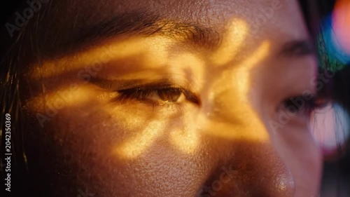 Close up of a person's eye illuminated by vibrant pink and blue neon lights