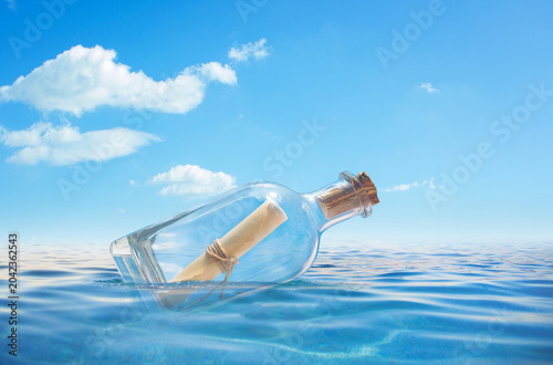 bottle with letter floating in the sea waves