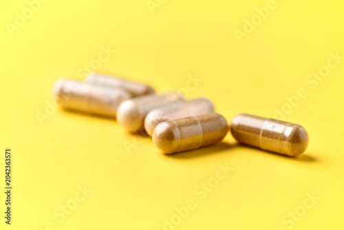 Rhodiola rosea. Golden root, rose root capsules.  Healthy supplement on bright paper background. Soft focus. Close up. Copy space
