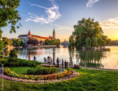 Lakeside park with castle at sunset
