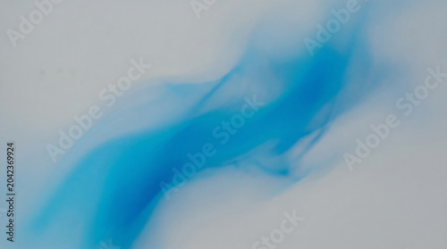 Abstract blue smoke or ink cloud swirling in water, ethereal flowing liquid texture, vibrant azure pigment dispersion isolated on white background