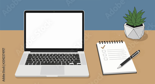 A laptop and a notepad with a pen and plant on a desk