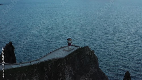 Aerial view of Faro do Cabo Ortegal lighthouse perched on steep rocky cliffs overlooking the Atlantic Ocean at dusk in A Coruna, A Coruna, Spain.