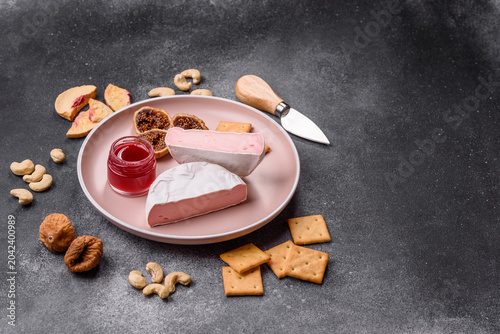 Bild auf Leinwand Pink Brie or Camembert cheese with honey, jam, figs, and crackers