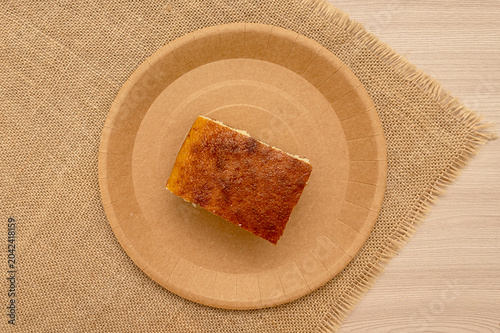 A slice of homemade pie on a craft plate. And burlap. Top view.