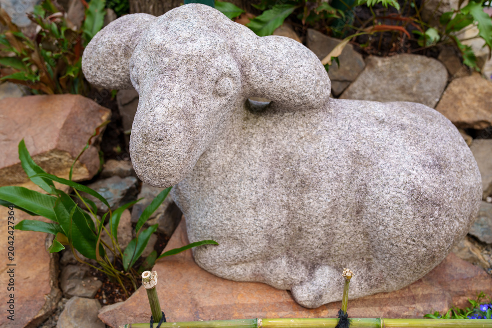 Φωτογραφία Adorable stone lamb garden figurine in a Japanese garden