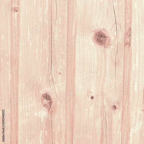 Soft pink wooden plank background with visible knots and vertical grain for r...