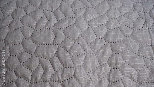 Quilted grey fabric creating an abstract geometric pattern