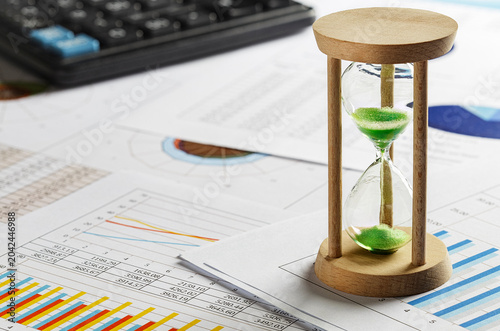 Fotografija hourglass on financial graphs and reports