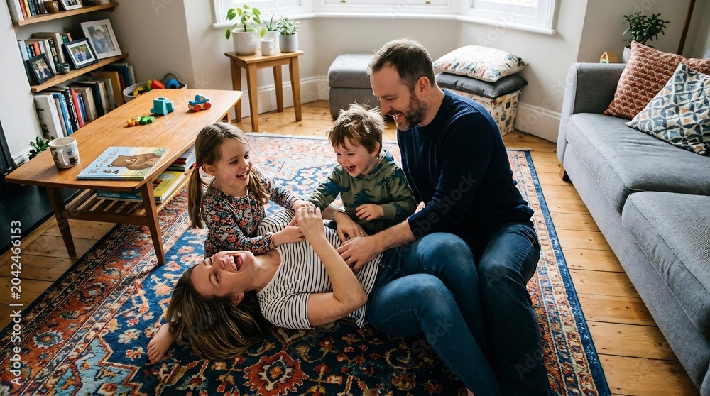 Obraz premium Joyful father playing with children and wife on living room rug, happy family bonding, laughing and tickling at home on Father's Day