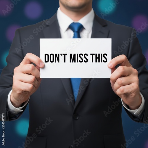 Businessman Holding Sign 'Don't Miss This' with Colorful Background