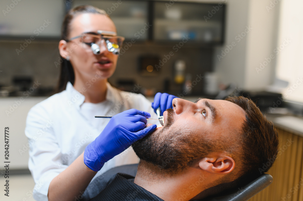Fototapeta premium Dentist examining patient's teeth during a checkup
