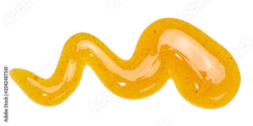 Photos A wavy smear of yellow mustard sauce with small spice flecks on an isolated background