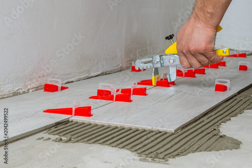 Professional ceramic tile installation using leveling system