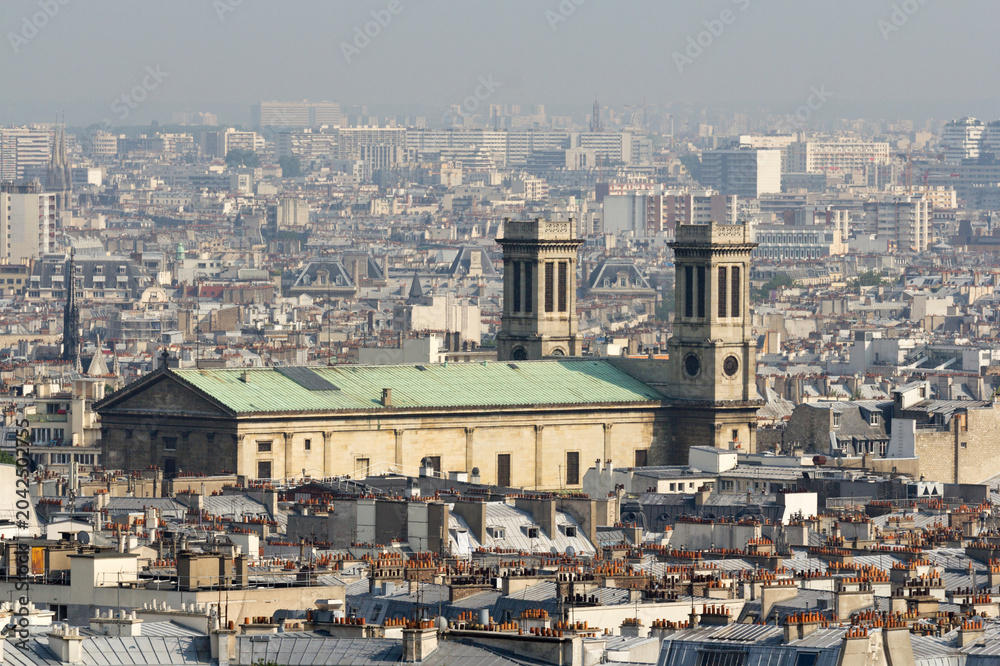 Obraz premium Paris cityscape, with Saint-Vincent-de-Paul church and dense rooftops