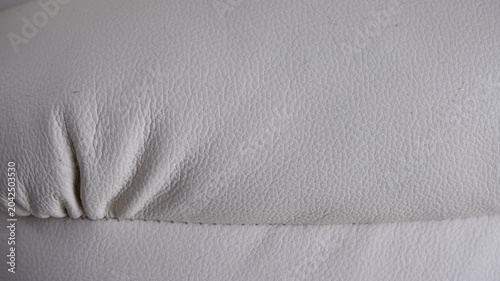 White leather upholstery texture with stitching and subtle wrinkles.