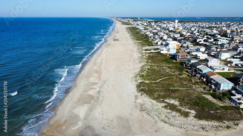 Fotografie Drone photograph of Atlantic Beach, North Carolina, showcasing a wide sandy shoreline, Atlantic Ocean waves, and oceanfront homes along the Crystal Coast