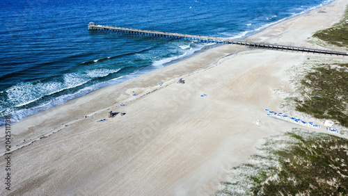 Fotografija Drone view of Atlantic Beach Pier extending into the Atlantic Ocean with expansive sandy beach, gentle waves, and coastal dunes along North Carolina’s Crystal Coast