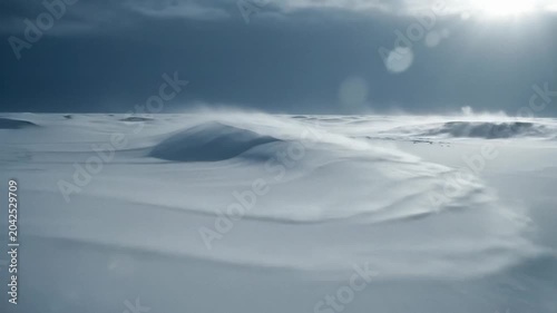 Snowdrift landscape under a pale winter sky, windblown powder sweeps across rolling dunes, quiet cold mood with soft light and minimal detail