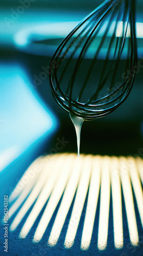 Whisk egg white drip kitchen mixing bowl shadow sunlight closeup