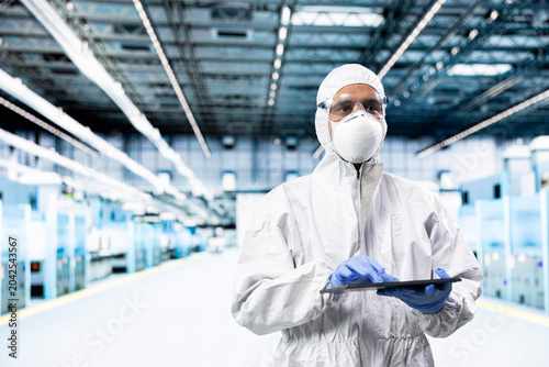 Bild auf Leinwand PCB systems architect walking in microchip factory, designing silicon wafers, Employee wearing protective gear inspecting semiconductor substrates infrastructure with device, doing quality control
