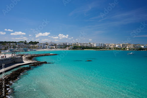 Harbour and coast of Otranto, Italy with single yacht turquoise sea and blue sky in summer