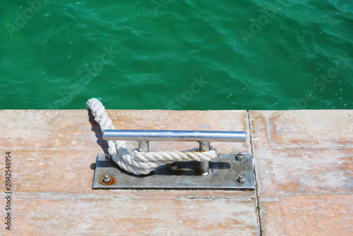 Dock cleat with rope on a pier.