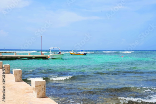 Sea view with boats and pier.